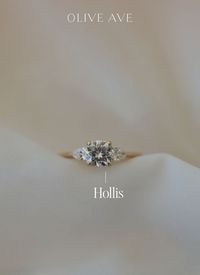 14K Yellow Gold | Hollis features a stunning cushion center stone with two pear side stones set in a three stone basket on a half round shank.