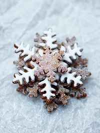 Piernikowe gwiazdki posypane bardzo drobnym cukrem kryształem, zawinięte w pergaminowy rożek    Lukrowane gwiazdki w surowej papierowej torb...