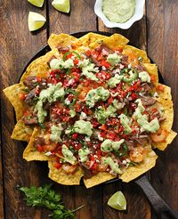 Grilled Surf 'n Turf Party Nachos with Avocado Cotija Sauce and Margarita Pico de Gallo from SoupAddict.com.  Summer party nachos topped with addictive avocado cotija sauce and fresh tequila spiked pico de gallo.