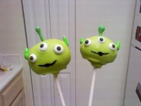 Toy Story Alien cake pops, covered in a mix of yellow and green candy melts.  Eyes are royal icing, antennas were made ahead of time from green candy melts, ears are candy coated sunflower seeds. TFL :D