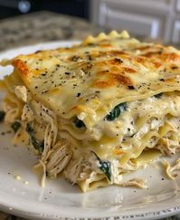 Creamy Chicken Lasagna with White Sauce  Ingredients  9 lasagna noodles 2 cups cooked, shredded chicken breast 2 cups ricotta cheese 2 cups shredded mozzarella cheese 1 cup grated Parmesan cheese 1 cup fresh spinach, chopped 3 cloves garlic, minced 1 small onion, finely chopped 2 tablespoons olive oil 4 cups milk 4 tablespoons butter 1/4 cup all-purpose flour 1/2 teaspoon ground nutmeg Salt and pepper to taste  Instructions  Prepare the Noodles: Cook the lasagna noodles according to package instructions. Drain and set aside. Make the White Sauce: In a large saucepan, melt the butter over medium heat. Add the minced garlic and chopped onion, sautéing until fragrant and translucent. Stir in the flour, cooking for about 1 minute until it forms a paste. Gradually whisk in the milk, continuing