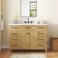 Infuse coastal chic into your bathroom with the allen + roth Wallister 48-inch bathroom vanity. Wallister pairs classic caning with a natural oak wood finish to deliver a beautiful centerpiece to your bathroom. The cabinet features a solid wood frame and 2 reversible soft-closing doors, so it’s easy to change the look from coastal to traditional. A tilt-down drawer, 8 soft-closing drawers, adjustable shelf, and power outlet provide abundant storage and convenience. The Natural laminated Carrara white marble top comes with a pre-installed rectangular sink and is pre-drilled for an 8-in widespread faucet. This midsize vanity is versatile, but Wallister is also available in a smaller 30-in profile for smaller bathrooms. allen + roth Wallister 48-in Wood Undermount Single Sink Bathroom Vanity