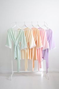 Our new Val bridesmaids robes are the sweetest! Available in many new Spring pastel shades. Pictured from left to right in: pale green, blush, bellini peach, ballet pink and lavender. All colors are in stock and ready to ship. Custom colors are available and made to order. Made of 100% silk crepe with Italian floral macrame lace trim on the sleeves, these sweet robes are perfect for getting ready pictures and they can be worn long after the wedding as a luxe robe or cover up. Features: Wrap kimo