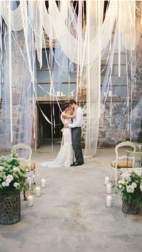 Dramatic wedding backdrop created with layers of sheer fabric and ribbon. #ceremony #decor