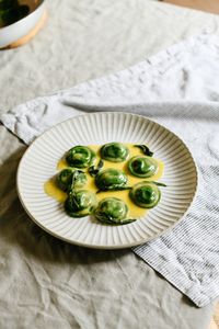 A classic pairing of ricotta, lemon and butter sauce. Cavolo nero lends its colour to both the pasta dough and filling, while a classic beurre monté sauce presents itself as the perfect vessel to serve.