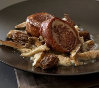 Pork tenderloin wrapped in prosciutto and placed atop a creamy mushroom ragout