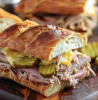 Enjoy a classic Cuban sandwich with tender slow-cooked pork, Swiss cheese, and pickles, all grilled to perfection.