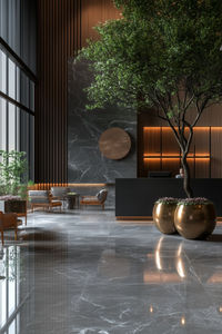 Discover the height of luxury in this contemporary hotel lobby, designed with Fringe AI. The space exudes elegance through sleek, minimal lines and sophisticated materials, including polished marble and warm wood accents. Ambient lighting subtly illuminates the grand design, creating an inviting yet opulent atmosphere. A striking indoor tree adds a natural touch, blending organic elements with the modern aesthetic. The combination of textures and soft lighting enhances the tranquil, refined ambiance, offering a seamless fusion of nature and luxury. Perfect for those seeking an elevated, sophisticated environment that redefines modern hospitality interiors.