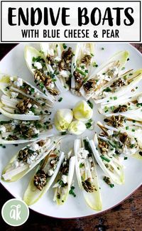 Endive boats with pear, blue cheese, candied pepitas, chives and citrus vinaigrette. This appetizer is festive and fresh, perfect if you're looking for a light and healthy appetizer. It happens to be gluten free and nut free. Leave out the cheese if you need to make it dairy free. #appetizers #endive #healthy #glutenfree #nutfree #bluecheese #pepitas