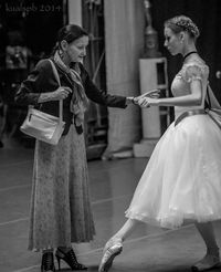 The woman on the left is showing or guide this young woman in some way, showing time doesn't effect knowledge. I see patience by how the young woman is watch her feet as she's being guide along.