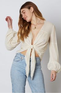 Show off your sense of style in the Gia Ivory Long Sleeve Tie-Front Crop Top! Gauzy ivory woven fabric cascades into a plunging neckline and cropped, blousy bodice with a tie-front design. Long, puffy lantern sleeves add a dramatic finishing touch to this sultry blouse. Gathered detail on hem and sleeves.