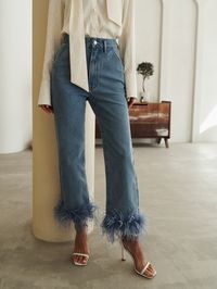 Straight cut jeans with a high waistline featuring fluffy feathers on the pant legs.- straight cut- high waistline- removable feather decor