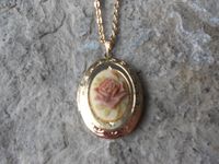 "Beautiful cameo locket  The cameo is a gorgeous Rose, choose pink or brown, many other styles and colors available in my shop, so please do browse  The locket is gold plated, victorian style with beautiful scroll on the front and back.  It can hold two photos, keepsakes, or even your daily medication or vitamins The chain is 20\" gold plated link chain with a lobster claw clasp Perfect  for Brides or Bridal parties.  Makes a unique memorable gift for any occasion  Timeless classic look, both ca