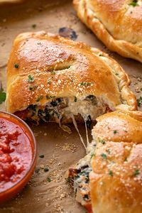 This calzone recipe is prepared with homemade calzone dough and a savory filling of ricotta, mozzarella, mushrooms and garlicky spinach! | thecozyapron.com #calzonerecipe #calzone #calzones #calzonerecipeeasy #calzonerecipedough #calzonedough