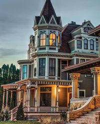 1-Exterior. The exterior of a Victorian style home has colorful intricate trimming around all of the exterior. Circular wrap around porches in the front. towers with pointed roofs.