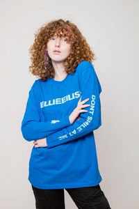 An official licensed soft-style cotton Long Sleeved Tee featuring the Billie Eilish 'Smile' motif. This high quality garment is available in a mid blue colourway. Comes in a wide range of sizes from Small through XX-Large, subject to availability.