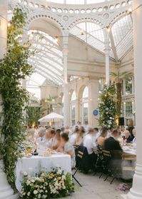 We turned Syon Park into an Italian courtyard with bistro chairs, parasols, statues, wrought iron furniture, festoon lights, and wild floral installations with a colour palette scattered with pastel blues and ochre yellow which perfectly complimented the impressive glass-panelled conservatory backdrop and stone floor.