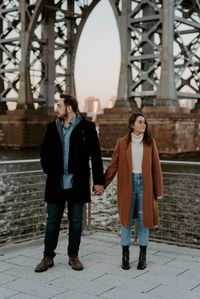 NYC Winter Engagement in Brooklyn | Couples photo ideas | Nicole Adrianna Photography. A romantic new york city engagement photoshoot in Dumbo, Brooklyn. The best place to go to have all of manhattan as the backdrops to your intimate couples photos! See tons of winter couple pictures, winter couple reference, brooklyn couple photoshoot and couple winter photoshoot ideas xmas cards. Book Nicole as your couples photographer at nicoleadrianna.com.