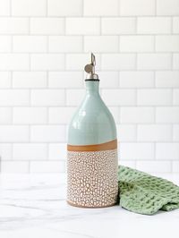 Large handmade stoneware olive oil bottle, glazed in the color of your choice combined with our signature crackle glaze. Holds approximately 30oz.Keep cooking oil handy and quick easy to pour. Great addition to any kitchen. Can also be used to serve your own homemade salad dressings. Ceramic bottle comes with a plastic and metal insert. With insert it measures approximately 11”h x 4”w Listing is for a crackle glazed oil bottle similar to the one shown on the left.. See available color options.Ea