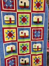 Handmade camper quilt. Has button embellishments. Measures 61x90 inches. Has a white backing, and has been professionally machine quilted.