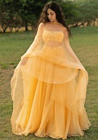 Featuring a beautiful summer yellow lehenga set crafted with pure silk organza base scattered with delicate embroidery. Teamed with a matching soft net modern blouse showcasing aari hand embroidery. Completing the look is the organza dupatta with all over embroidered motifs and tassels. Perfectly poised for a memorable wedding reception, it ensures you captivate with elegance and grace. Composition : Lehenga, Dupatta - Organza, Blouse - Soft Net Care: Dry Clean Only and Vacuum Storage This product can be customized for sleeves, length of blouse and neckline Delivery : 4-6 weeks as the product is hand crafted. Check Size Guide or choose MySize for free customisation (All Sizes above XL can be made at 15% additional cost) For more information and sizes please contact fabiliciousfashion@gmail