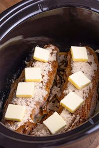 Butter slices on gravy mix covered pork tenderloins.