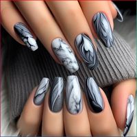 The nails are adorned with a sophisticated water marble design in shades of gray and white. The colors blend in a way that mimics the look of natural marble stone, creating a sleek and elegant effect. The monochrome palette adds a touch of classic sophistication to the design.