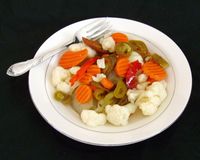 Wiki: Giardiniera: Italian Relish of Pickled Vegetables (bell pepper, celery, carrot, cauliflower, gherkin) marinated in oil, red/white wine vinegar, herb, spice. Also called: Sottaceti "under vinegar" common term for pickled foods. Eaten as antipasto or with salads. Also with: Bratwurst, bruschetta, burger, pasta/tuna salad, omelet, hot dog. Milder form for muffuletta olive salad. Chicago-style: hot (sport peppers) or mild on pasta, pizza, Italian beef sandwich. | Wikipedia