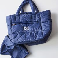 Perfect for ski days, running errands, or your next vacation, this water-resistant tote is crafted from durable yet incredibly soft, lightweight polyester. Thoughtfully designed to save space when packing or traveling, this quilted puffer tote can be folded and stored in the small zipper pouch it comes with so you can pack more into every trip. markandgraham.com