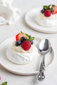 Mini pavlova served with whipped cream and fresh berries. Recipe makes 4 easy mini pavlovas that are perfect, but you can double it.