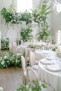 Heavy green foliage and pastel roses adorn this modern twist on a wedding reception banquet table.