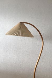 Very elegant floor lamp by Mads Caprani for Caprani Light, This lamp features a nice beech wood stand with an elegant curve and a cast iron base. The shade is made out of linen.