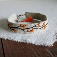 Esta pulsera brazalete bordado de mano tiene un diseño de rama con naranja otoño follaje cosida en lino natural suave, tiene un cierre de broche de langosta de tono cobre y se termina con una borla pequeña naranja Tamaño: Que ajusta cómodamente un tamaño de la muñeca entre 7,25 y 6 pulgadas. Cada pulsera se hace para caber una variedad de tamaños de muñeca y ofrecer flexibilidad con cómo o le gustaría usar. La parte de tela de la pulsera es de alrededor de 6,25 pulgadas largo por.5 pulgadas de