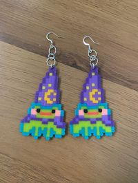 This is a pair of earrings I made of magical wizard frog friends! They're made out of mini perler beads & I tried to give them a pleasing color palette while staying true to that "wizard frog feel." Hope you'll enjoy!