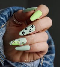 Pastel green polish in matte finish with frog nail art on long almond nails