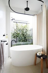 The success of this home is due to smart use of space and refined details. The bathroom is a great example with a tub in front of a private courtyard for a day spa feel and black [Astra Walker](http://astrawalker.com.au) taps for a modern twist Stylist: Heather Nette King, Photographer: Armelle Habib