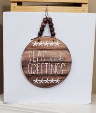 I just love Seas and Greeting signs. I have a couple others in my shop. I think it is such a good Christmas Sign. I love the brown stain on this with the aqua and of course a bead hanger. This sign has been hand painted and sealed by me. It measures 6.5 inches round. You could hand this unique sign in any room-on the tree-or give it as a gift to a beach loving friend. This would also make a perfect hostess gift.  If you would like this sign in a different color-send me a message. If you would li