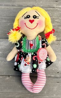 Christmas doll with a santa dress on and she holding a lollipop! Isnt she sweet!