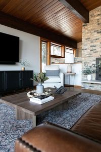 Elevated cabin living room. Amber Lewis. Amber Interiors. Restoration hardware. Moody and natural living room space. Balanced space with lights and darks. Coffee table decor. Seating to copliment a fireplace. Natural light.