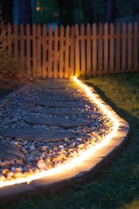 Brighten gardens and walkways using rope light as pathway lights! Great along stone walkways and a perfect #DIY idea for backyard lighting and weddings, too!