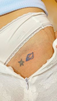 Small tattoo of shell and sea star in blue ink