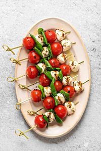 Caprese Salad Skewers Recipe - Handy Caprese skewers are a delicious and fun version of a classic Italian salad. This recipe is easy to make with mini tomatoes, mozzarella balls, fresh basil, and a flavorful balsamic reduction. Perfect for an effortless but impressive appetizer or healthy snack! | Cubes N Juliennes