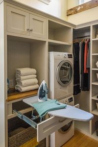 This laundry closet showcases unique organization features from a pull-out iron board drawer to corner built-in shelf system.