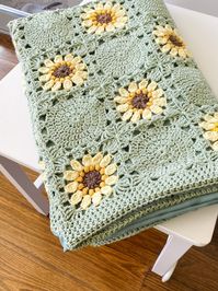 Discover the Crochet Granny Blanket with a vibrant boho sunflower design. Perfect for home decor or travel, this cozy throw adds charm and comfort to any space.