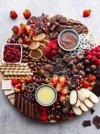 This chocolate charcuterie board is a chocolate lover's dream! Enjoy a chocolatey assortment of cookies, truffles, chocolate-covered pretzels, and fruit, along with decadent sauces for dipping!