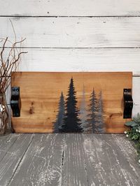 This large, versatile tray is not just functional but also a piece of art, featuring a custom hand-painted design on a rustic cedar wood surface that has 2 coats of Tung oil. The handles are made from recycled belts and the legs are slices of wood. This 22 inch by 11 inch pedestal tray is perfect to use as a riser disp