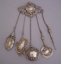 1897 Sterling chatelaine with pin back: glove hook, mirror, perfume, aide memoire or notepad, repousse pill box engraved.