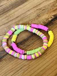 two clay bracelets that have yellow, pink and green colors. the match perfectly together