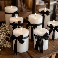 add black bows to white candles to create a classy Halloween vibe