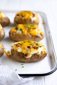 The BEST Twice Baked Potatoes Recipe - cheesy, creamy, and loaded with fluffy mashed potatoes, gooey cheddar cheese, crumbly bacon, and fresh chives. Learn how to make these Easy Twice Baked Potatoes and enjoy as an easy side dish, appetizer, or satisfying meal.